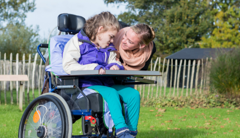 A young person in a wheelchair smiling.